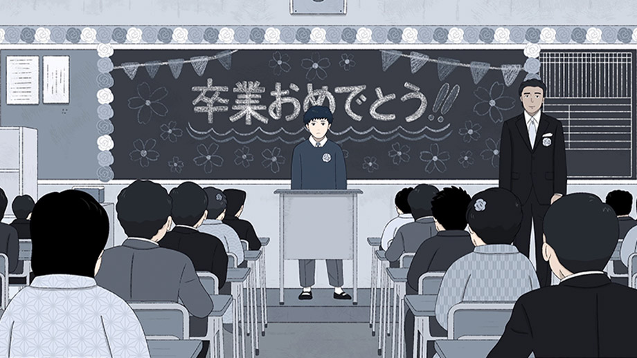 Jinsei standing and speaking in front of his class while a teacher smiles on.