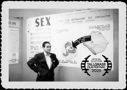 Black and white photo of young Noguchi in front of a chart showing how to determine sex of a corpse.